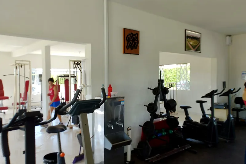 Academia com esteiras, bicicletas e área de musculação